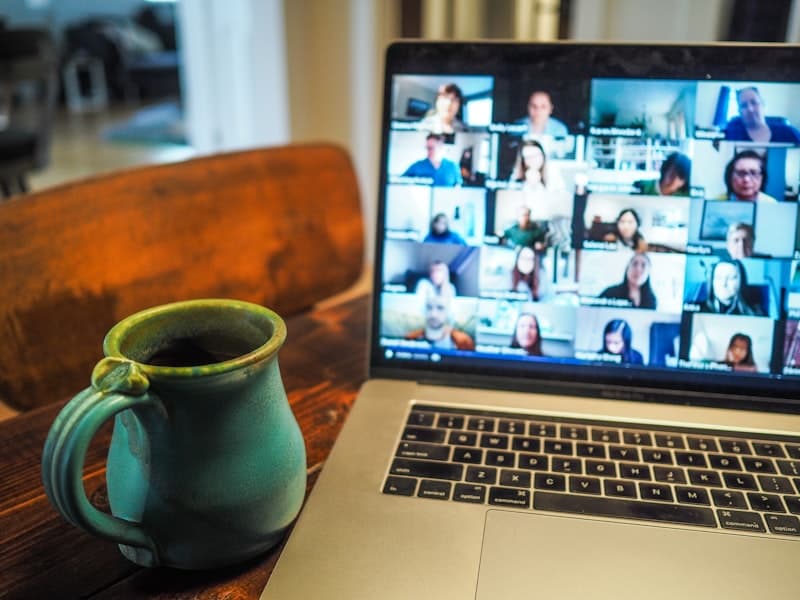 Laptop showing a live video lesson beside a coffee mug