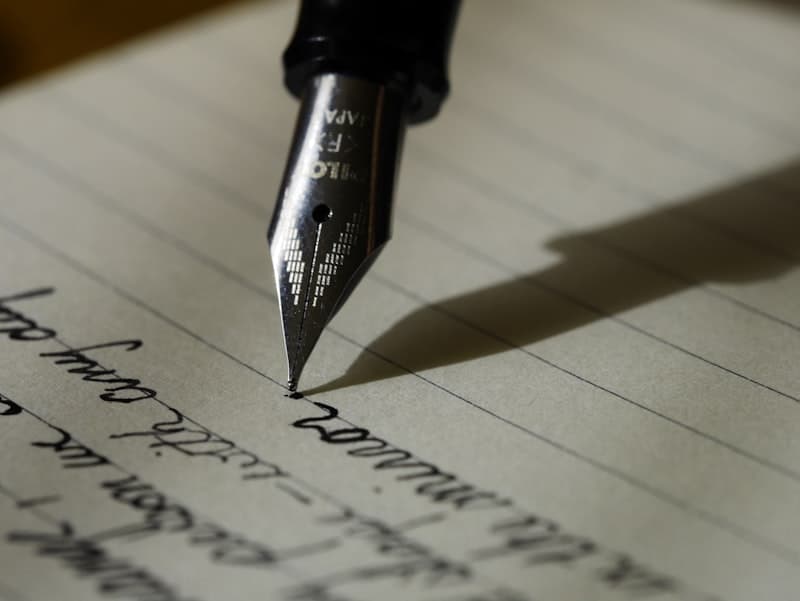 Close-up of a fountain pen writing on lined paper