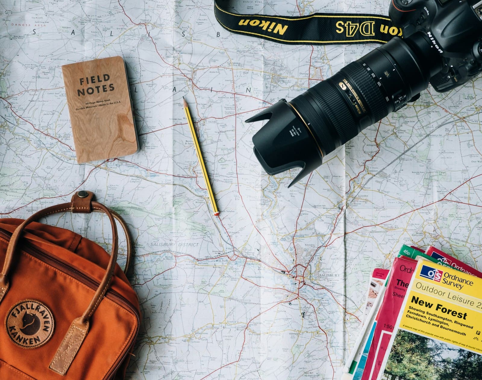 A map, camera and backpack laid out while planning a trip